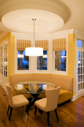 A dining room with tables and chairs with a hanging light 